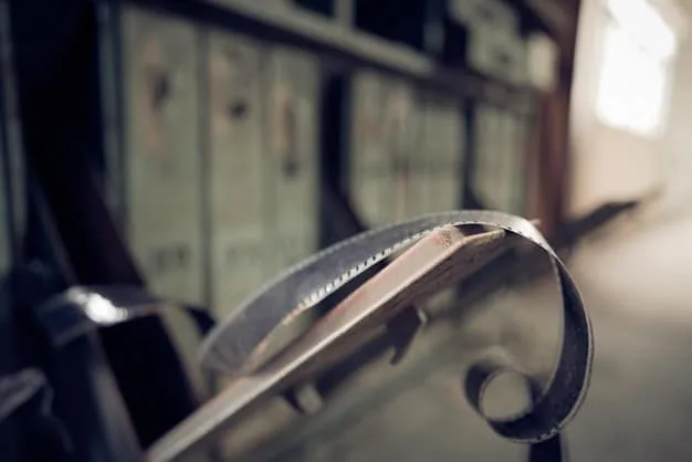 A close-up shot of a film reel being carefully inspected by a film archivist wearing gloves. The lighting is focused and precise, highlighting the detail of the film and the archivist's meticulous work. The scene represents the dedication required for