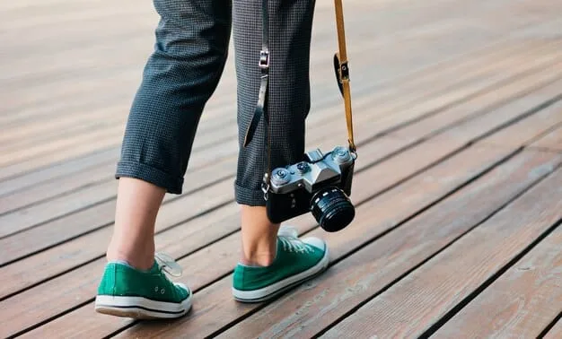 A filmmaker using a simple, home-made dolly system consisting of a wooden plank and skateboard wheels to achieve a smooth tracking shot, demonstrating cost-effective solutions on set.