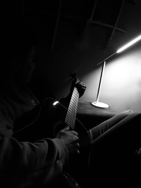 A scene from a cult documentary showing a musician composing a soundtrack in a dimly lit studio.