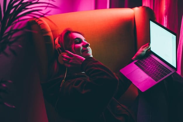 A person sitting on a couch, illuminated by the glow of a laptop screen displaying a popular streaming service interface, with several indie films prominently featured.