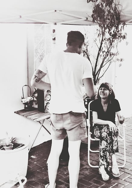 A black and white photograph showing  as a young artist. They are standing in their studio, surrounded by canvases and art supplies, with a focused expression on their face. The photo captures a sense of dedication and passion for their craft.