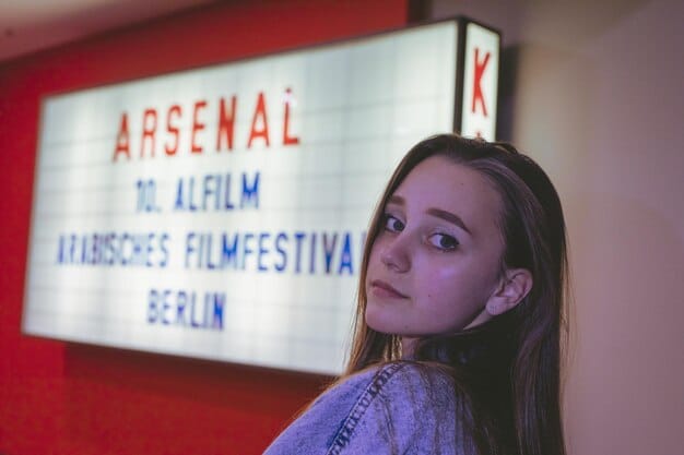A close-up shot of a person's eyes intently focused on a cinema screen, with subtitles visible at the bottom. The image should convey a sense of engagement and immersion in the film, highlighting the seamless integration of subtitles into the viewing experience.