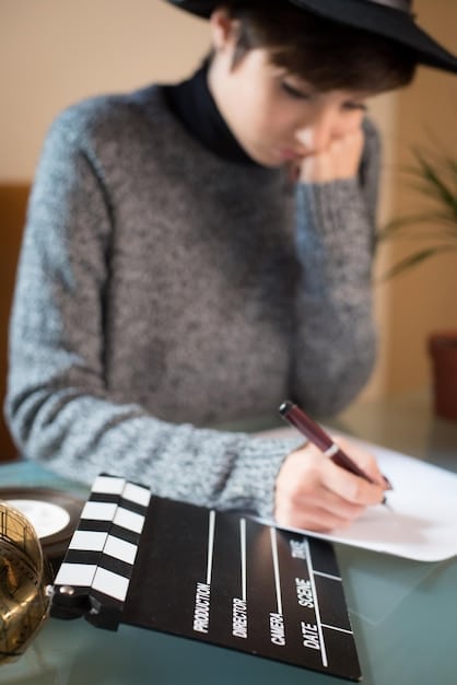 A close-up photo of a film critic taking notes during a screening at the Cannes Film Festival. The critic has a focused expression, and the details of their notepad and pen are visible.