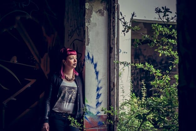 A still from 'Repo Man' showcasing Emilio Estevez as Otto, dressed in punk-inspired clothing, looking confused and rebellious. The background shows a gritty urban setting with graffiti-covered walls.