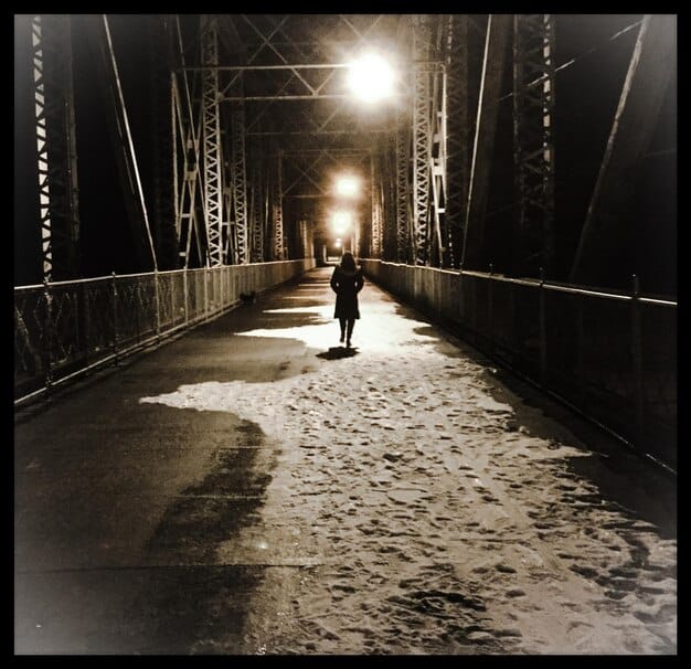 A single actor in a film running down an alleyway at night, captured in a continuous shot, conveying a sense of urgency and immediacy, illustrating The Art of the Long Take: Analyzing 3 Masterful Examples in International Cinema.