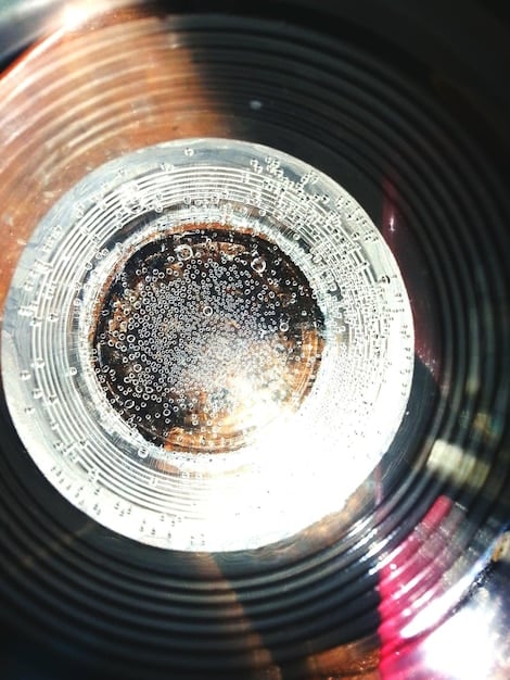 A close-up, slightly distorted photograph of a vinyl record spinning on a turntable. The record label is partially visible and suggests it's the soundtrack to 'The Warriors'. The lighting is dim and atmospheric, emphasizing the analog nature of the music.