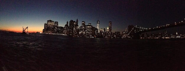 A panoramic view of the New York City skyline, but depicted as a dark and decaying wasteland. Fires burn in the streets, and iconic landmarks are shown in ruins. The image vividly conveys the dystopian atmosphere that contributes to The Enduring Appeal: Why 'Escape from New York' Remains a Cult Favorite 44 Years After Its Debut.